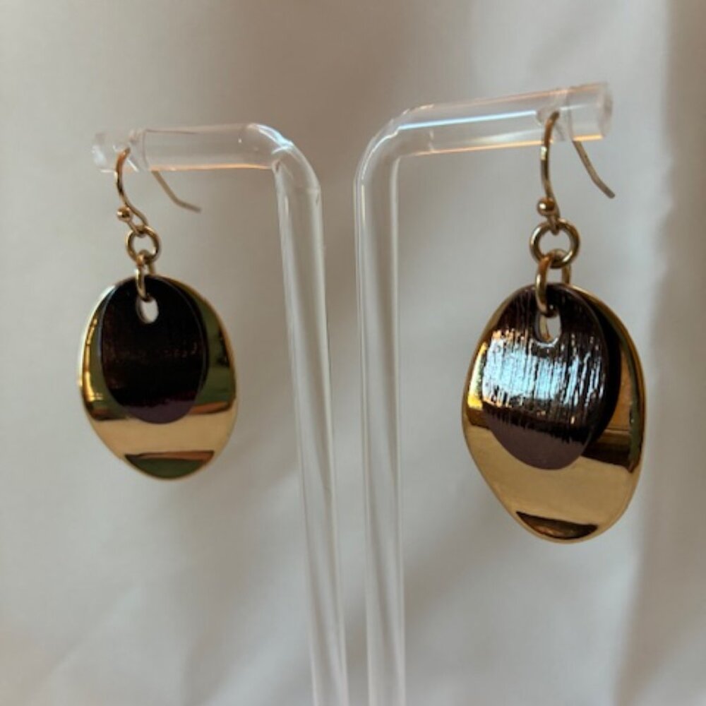 Earrings - dangling with brown flat bead over gold tone leaf.